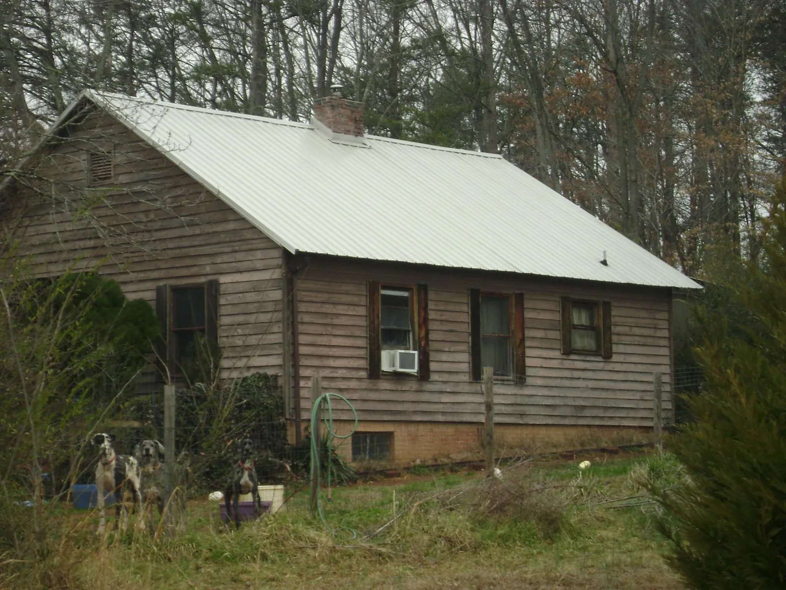 White metal roof on an old wood sided farmhouse, from a Metal Roof Installation job in Stem